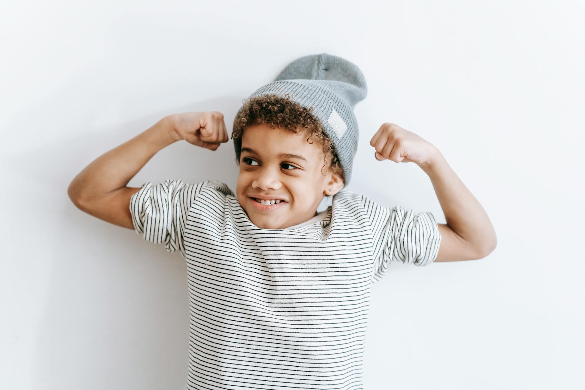 cheerful black boy showing biceps